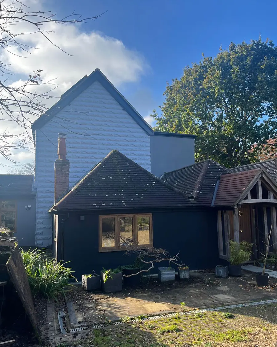 A house clad in dark timber with oak framed windows, finished by O&S Building Services