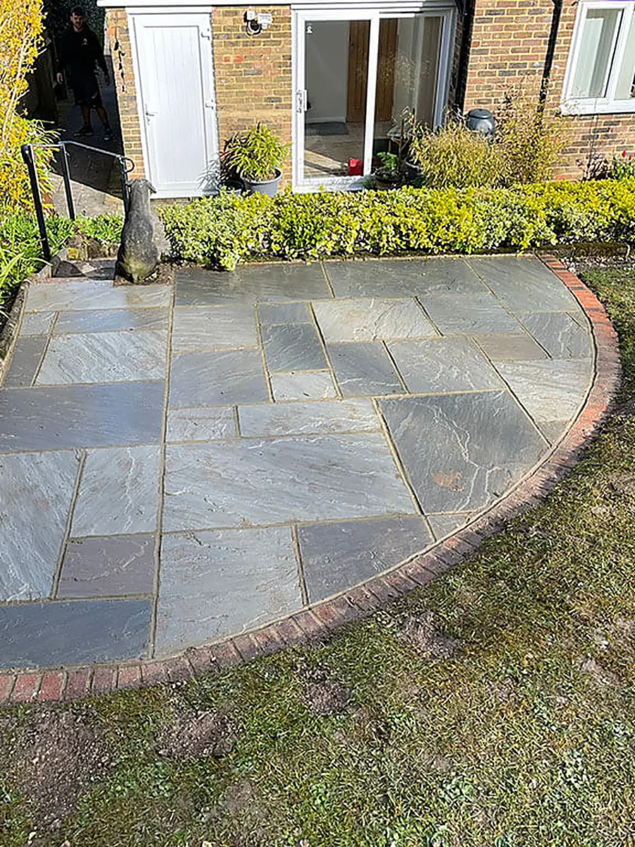 An Indian sandstone circular patio with brick edging