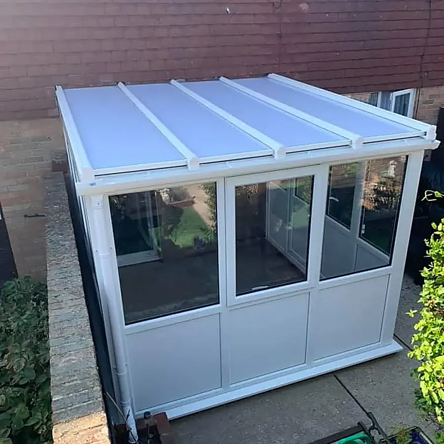 A white lean to garden room with a solid roof on a brick base