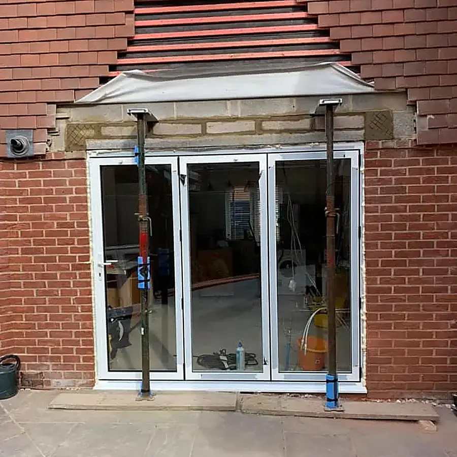 Bifold doors being fitted to a new brick rear extension