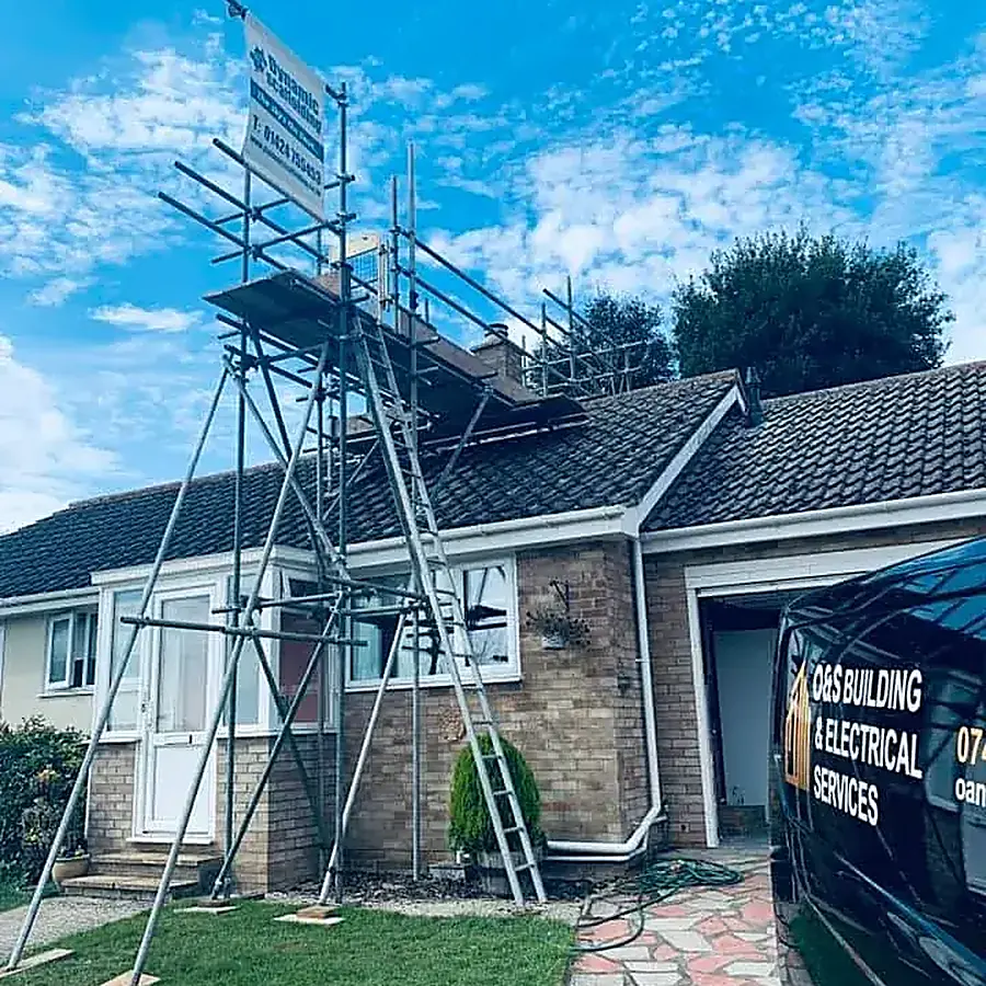 A bungalow under scaffold with the O&S Building Services van outside