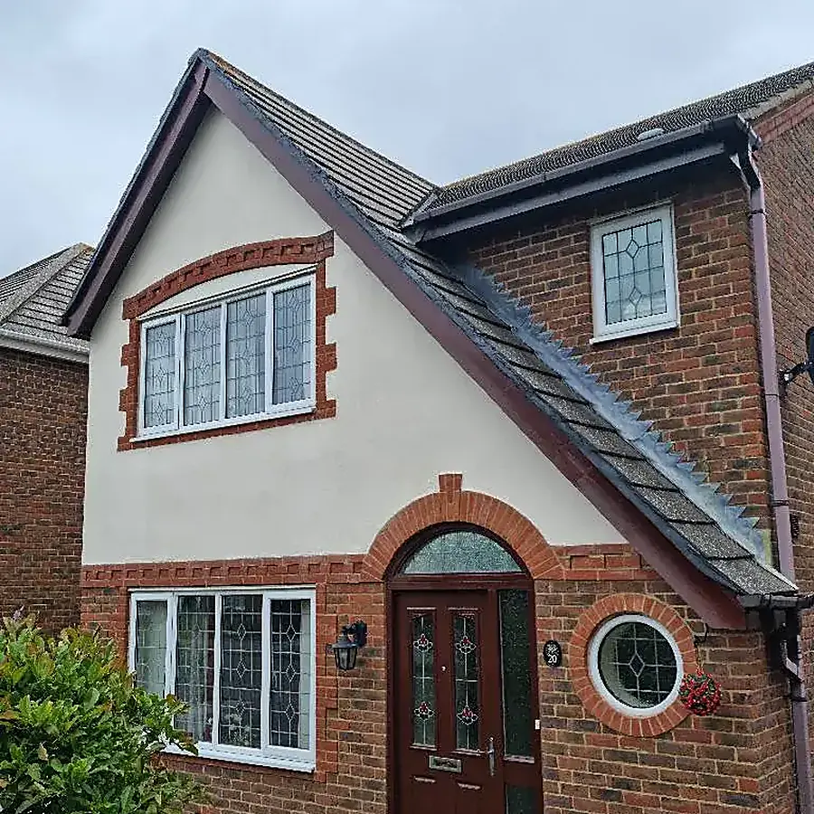 A detached house in red brick and white render with an arched porch
