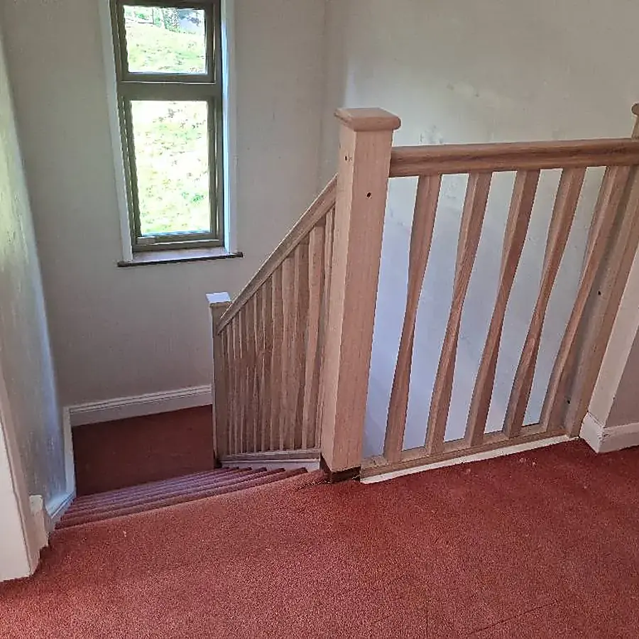 A new oak staircase with a square newel post and oak spindles