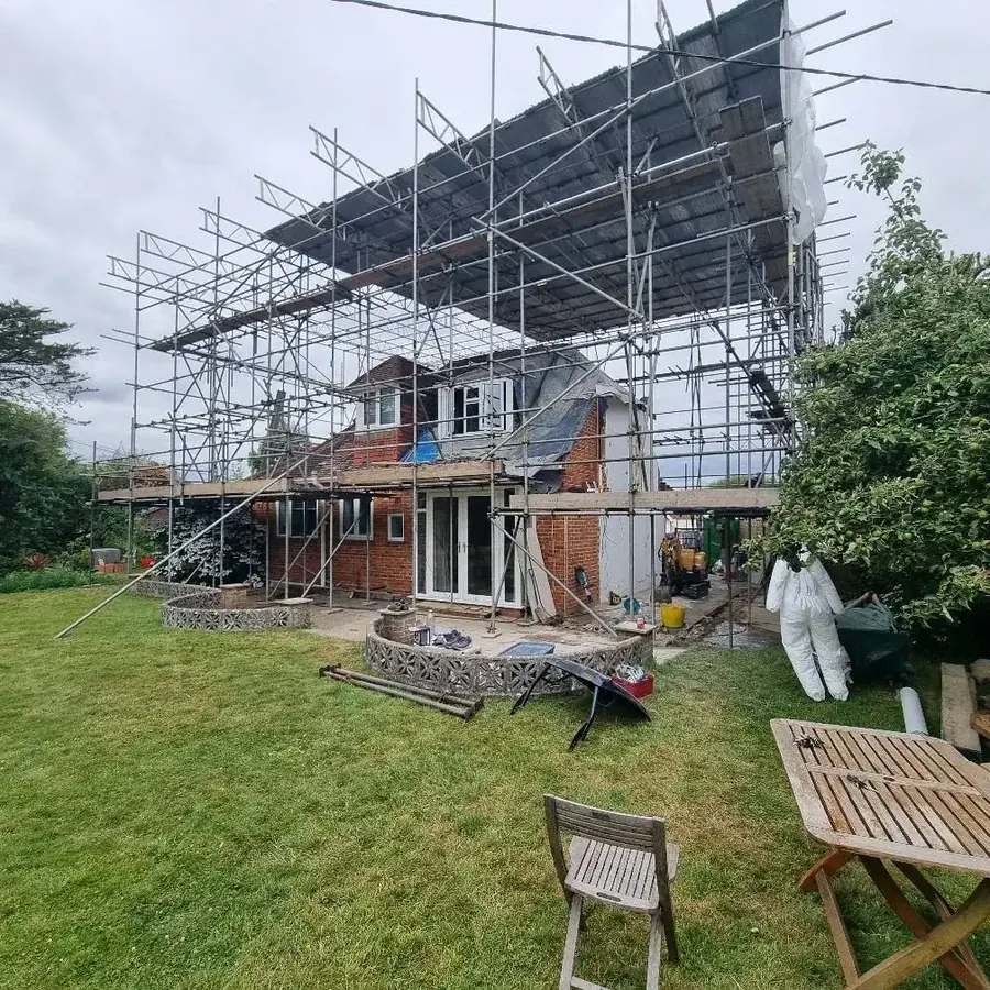 A house under scaffold with a two storey extension being built