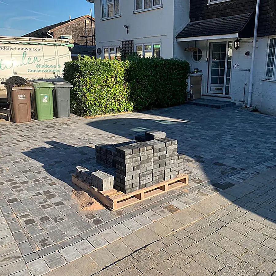 A block paved driveway part laid with pallets of blocks stacked