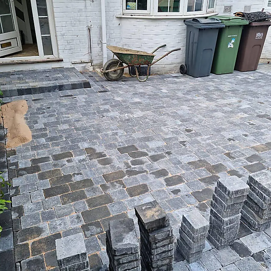 Stacks of grey block paving on a driveway under construction