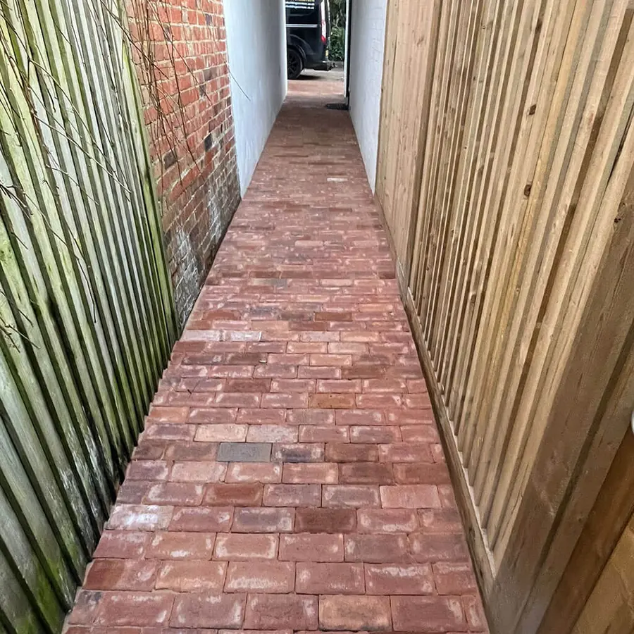 A red brick paved side passage with new fencing
