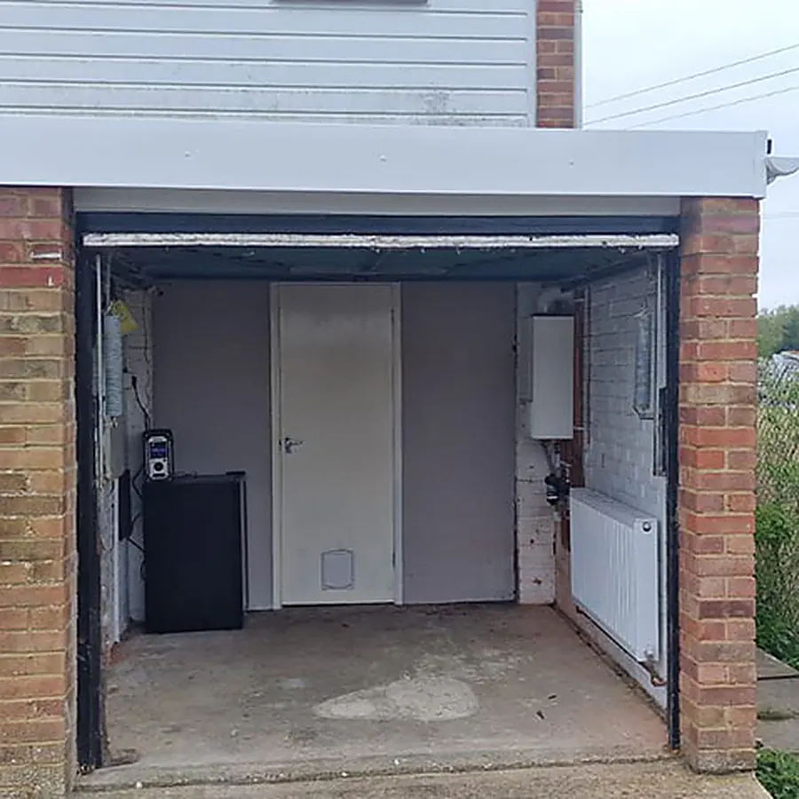 A garage with the door open being converted into a room