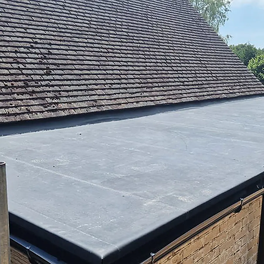 A finished flat roof with black trims beside a tiled roof