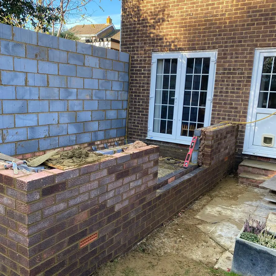 Block walls of a new extension beside existing patio doors
