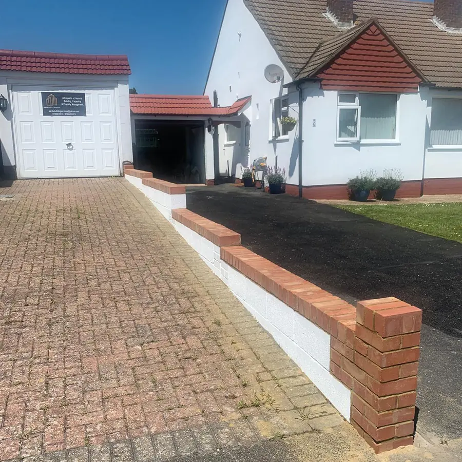 A block paved driveway with a new brick boundary wall to a bungalow