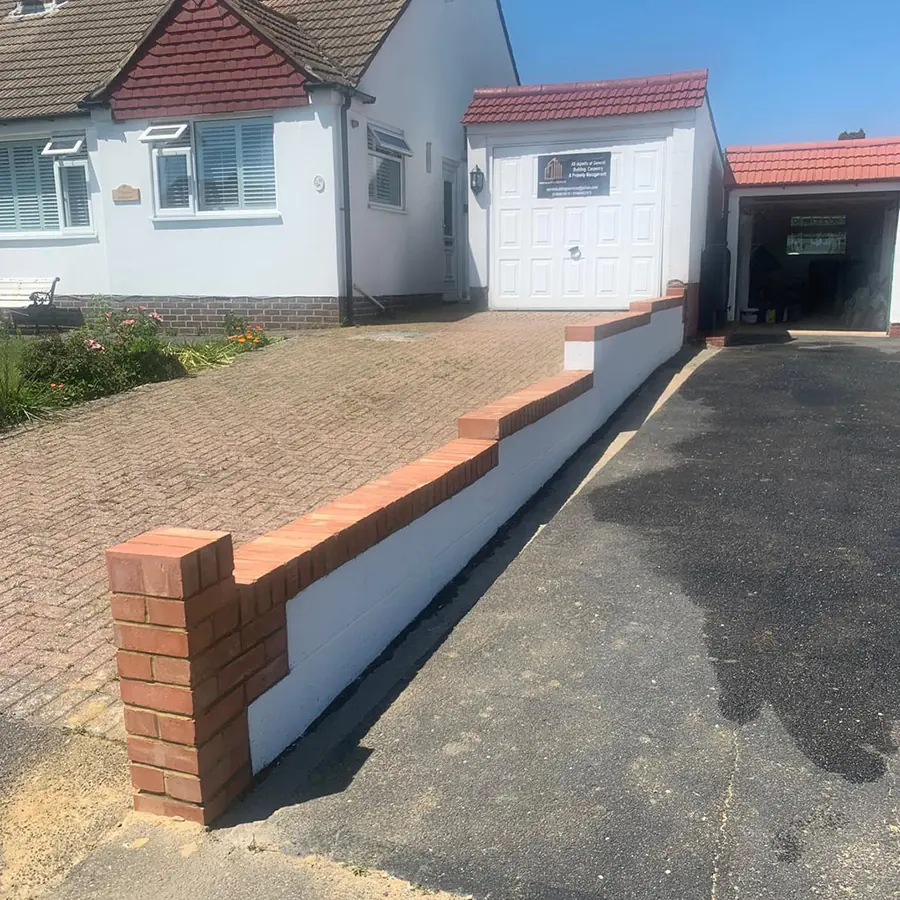 A new brick boundary wall beside a driveway to a bungalow