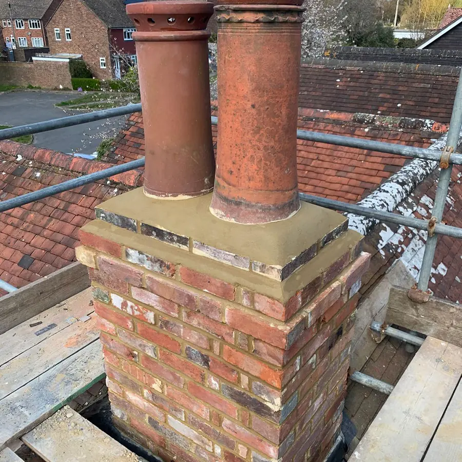 A rebuilt brick chimney stack with new pots