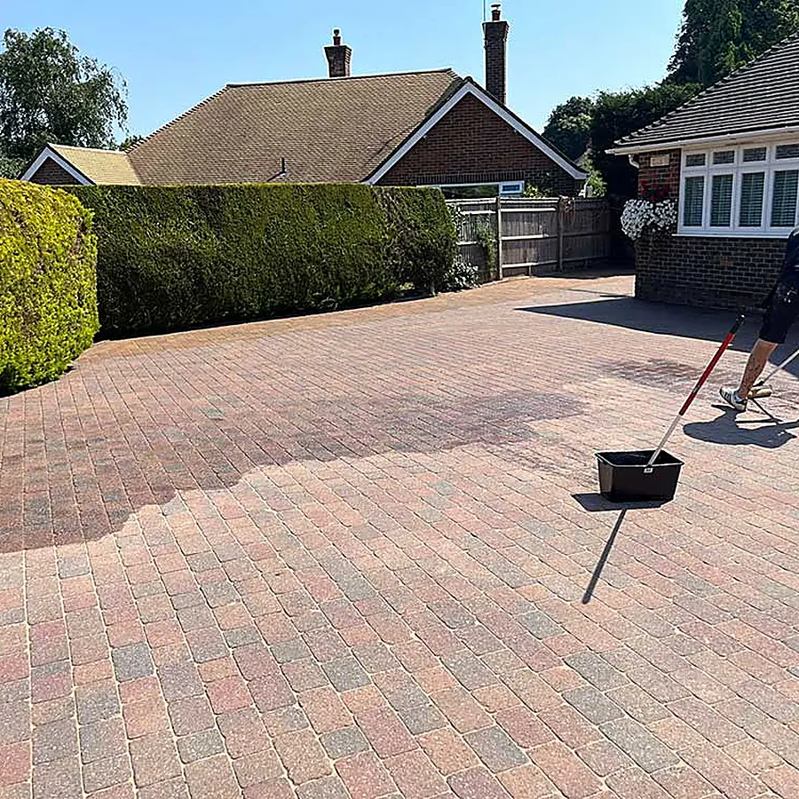 A wide red block paved driveway being finished