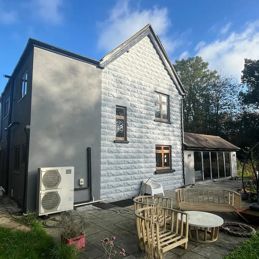 A house with white cladding and a new extension