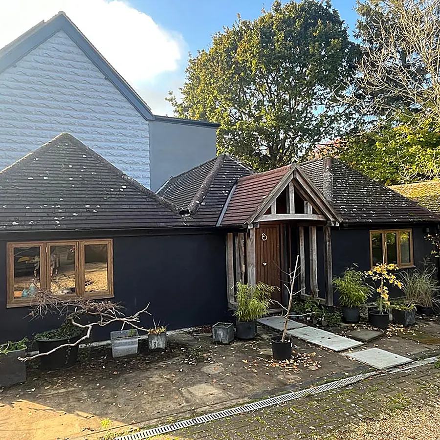 A dark timber clad annexe with an oak porch